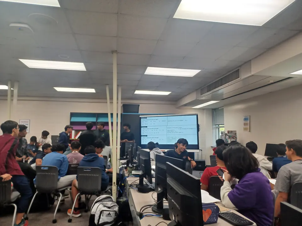 A packed meeting working through contest-style Java questions on the screen.