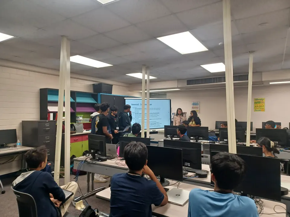 Officers present the club's general information slide to a full computer lab.