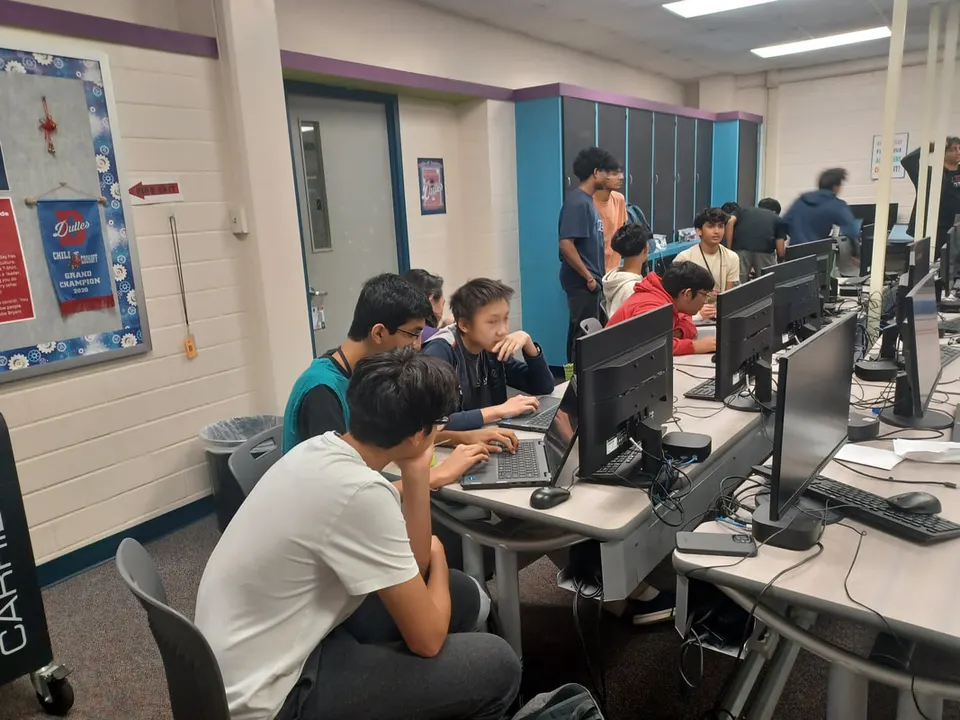 Members working through problems on laptops in the computer lab.